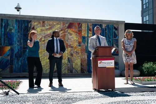 A man speaks at a podium outside.