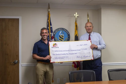Two people pose with a giant check.