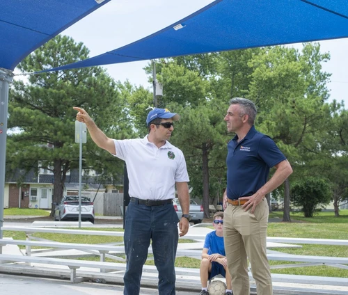 Two men talking and pointing off camera.