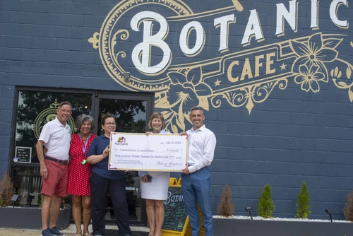 A group of people posing with a giant check.