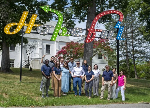 A group of people posing under a sign that says "Hopeful".