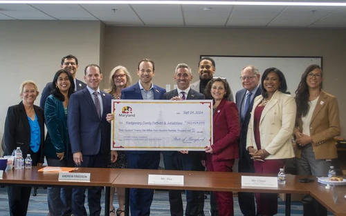 A group of people holding a giant check.