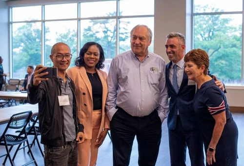 A group of people pose for the camera smiling.