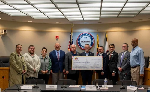 A group of people holding a giant check.