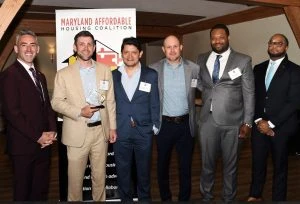 A group of people in business clothes pose for a picture.