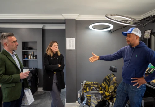 Three people in a office room talking.