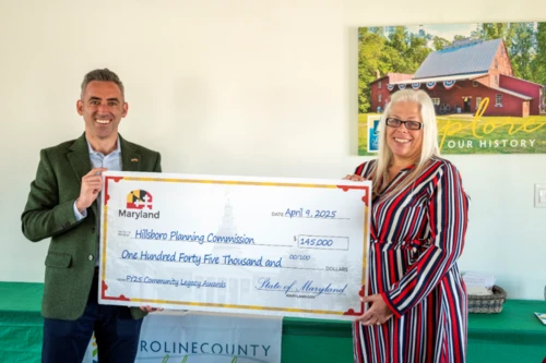 Two people holding a giant sized check.