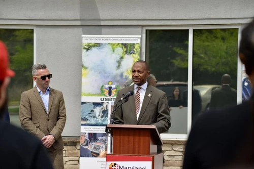 A man speaks at a podium outside.