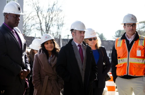 A group of people with hard hats looking off camera.