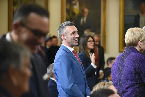 Jake Day smiling in a government building.