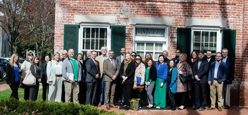 Group of people posing in front of a building.