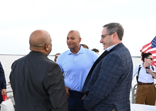 Three men talk outside.