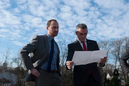 Two men in suits looking at a map.