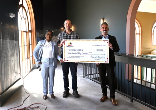 Secretary Day presents Sangfroid Distilling owner with a ceremonial check for $150,000 in Department funding.