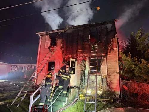 A burning home with Maryland State Marshals climbing the steps