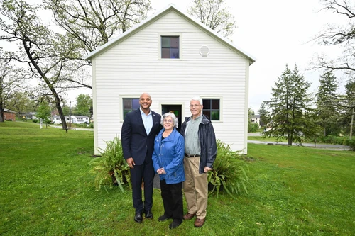Governor Moore in group photo in front of house