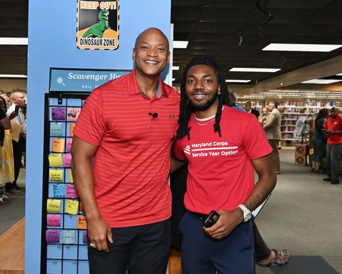 Governor Moore with young man wearing a shirt reading "Maryland Corps Service Year Option"
