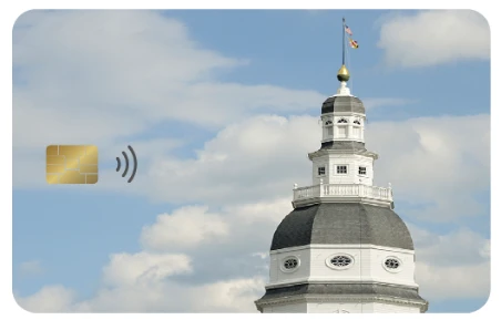 A payment card design featuring a photo of the Maryland State House dome against a blue sky with clouds, with a gold EMV chip and contactless payment symbol in the lower left.