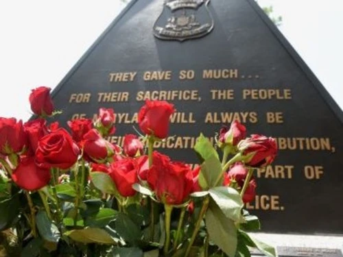 A tribute to Maryland State Police fallen heros with flowers in front of a statute