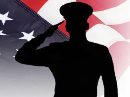 A Maryland Department of State Trooper saluting with the American flag in the background