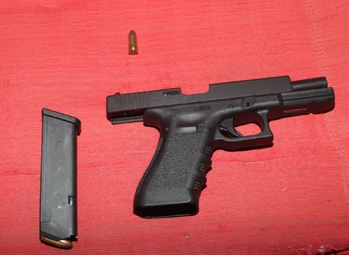 A black handgun with a red background