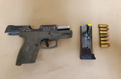 A black handgun with a magazine and ammo. 