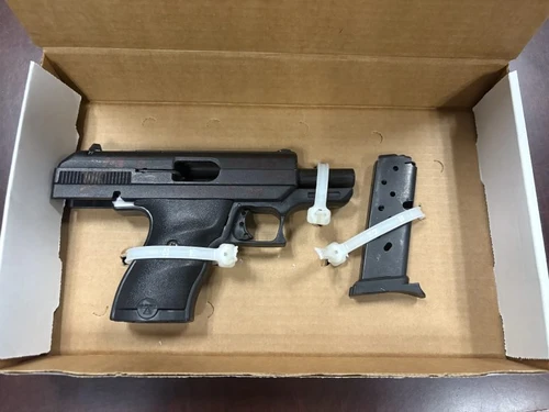 A black handgun with white zip ties. 