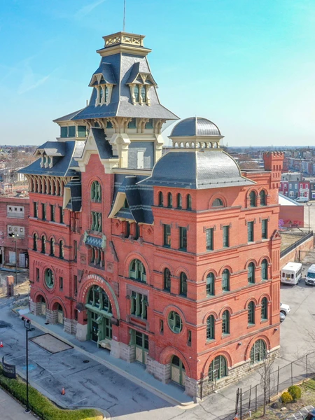 The historic American Brewery Building in Baltimore with red-brick architecture and an ornate central tower under a clear sky.