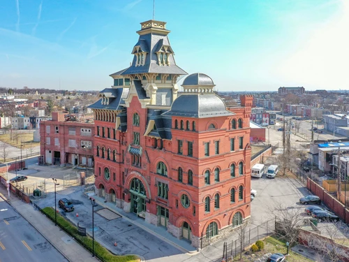 The historic American Brewery Building in Baltimore with red-brick architecture and an ornate central tower under a clear sky.