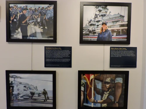 Framed photos and plaques on a wall.