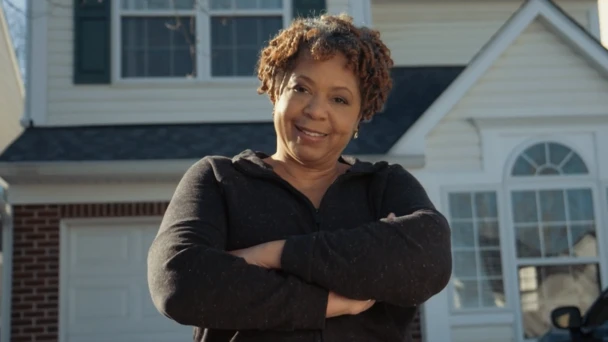 Rhonda Wanzer standing in front of her new home