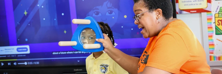 Teacher using glass object in classroom.