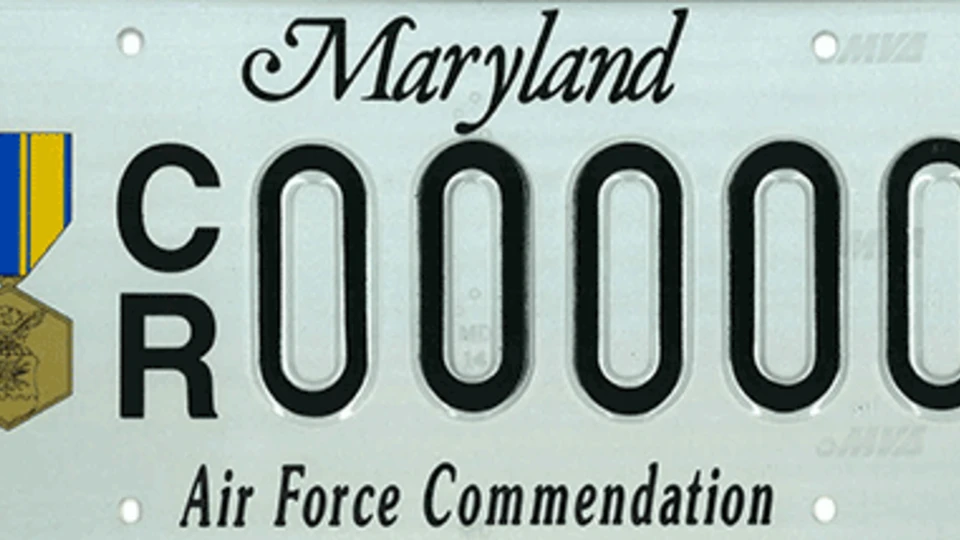 Light blue plate with the Air Force Commendation medal to the left of the plate number.