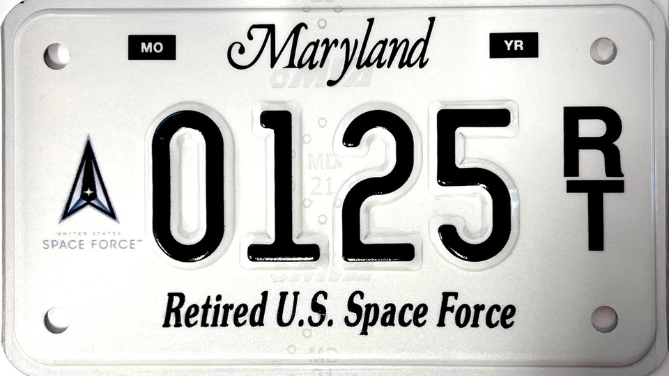 White license plate with the Space Force seal to the left of the plate number.