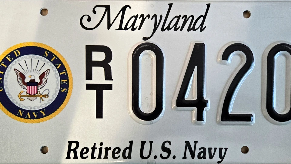 White license plate with the Navy seal to the left of the plate number.