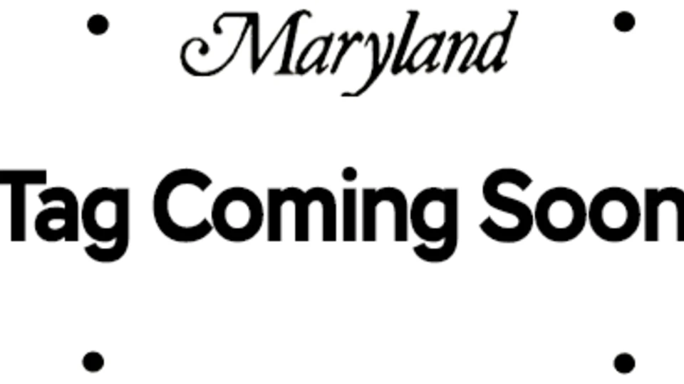 White sign with four black screw holes featuring the Maryland state logo and the words "Tag Coming Soon" in bold black text.