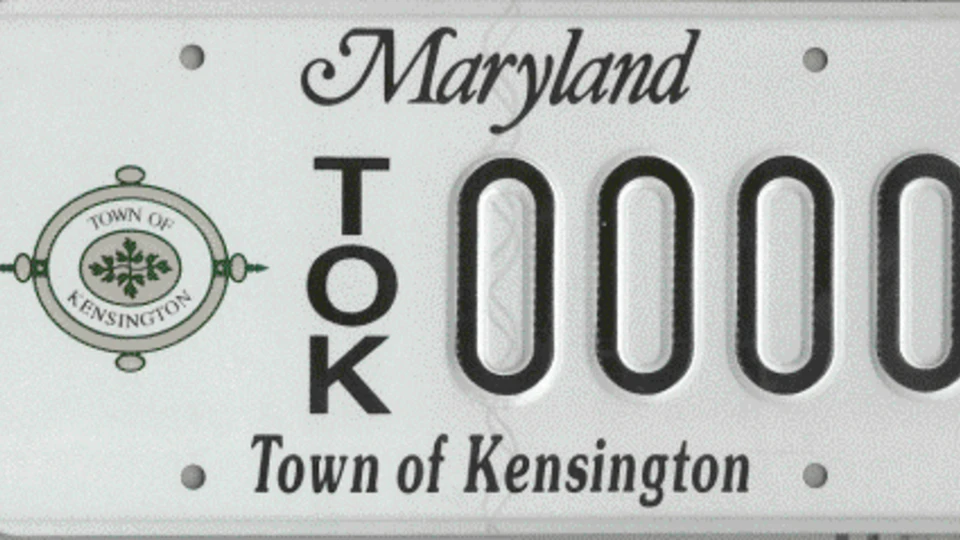 Maryland license plate for the Town of Kensington featuring the town seal, the letters TOK, and the number 0000 in black text on a white background.