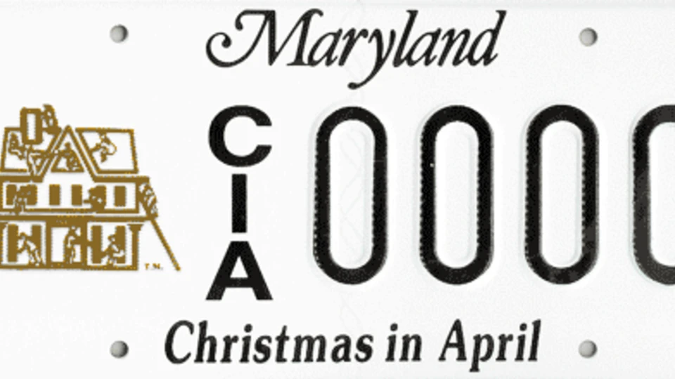 A Maryland specialty license plate with "CIA 0000" and "Christmas in April" text, featuring a gold graphic of people working on a house.