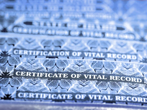 stack of birth certificates that say certificate of vital records