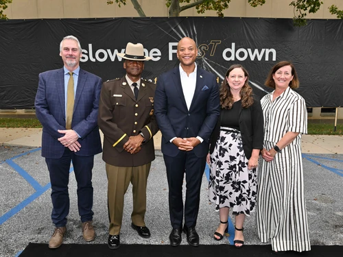 Gov. Wes Moore, Secretary Katie Thomson, MVA Administrator Nizer, Colonel Jackson, IHS Rep standing in front of the Slow the Fast Down giant banner