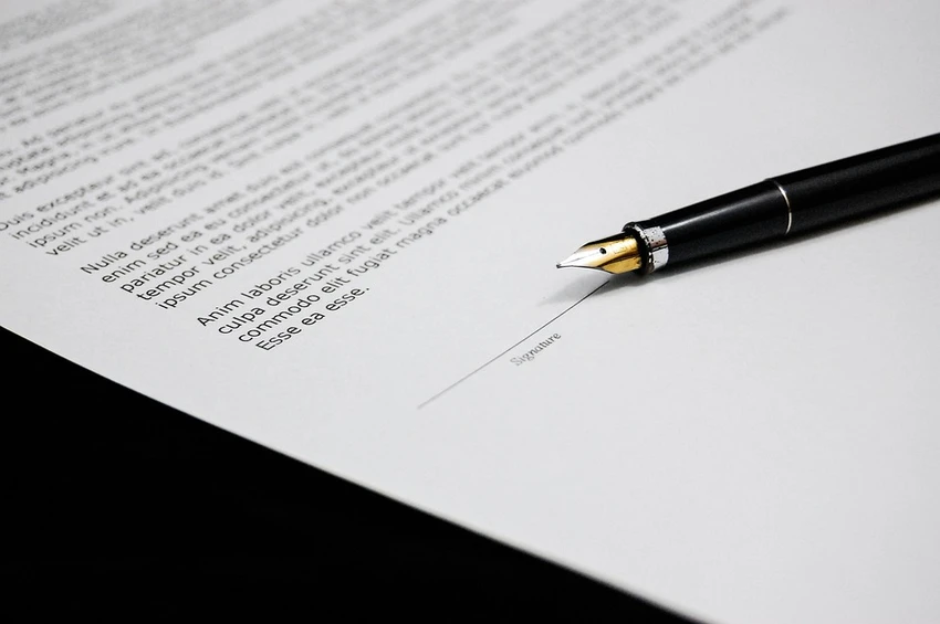 close-up of a document with a pen placed near a signature line
