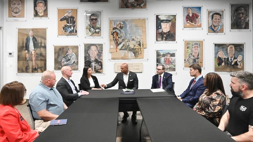 gov wes moore at a table with veterans and leaders speaking