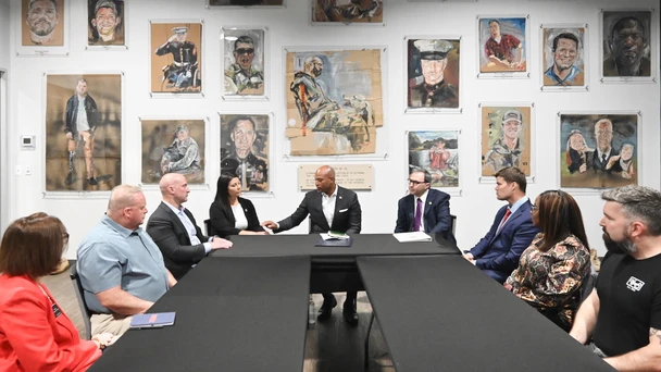 gov wes moore at a table with veterans and leaders speaking