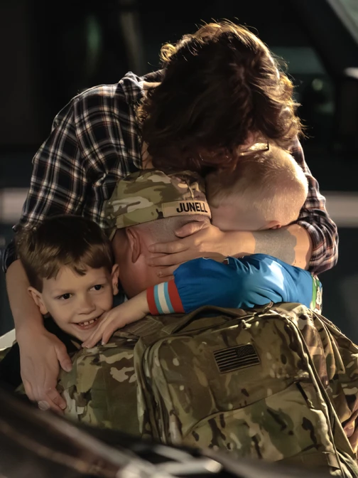 solider hugging family