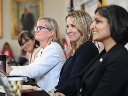 Members of a cabinet meeting are seated and smiling